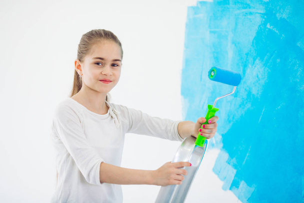 Reparatur in der Wohnung. Glückliches Kind malt die Wand mit blauer Farbe, - Foto, Bild