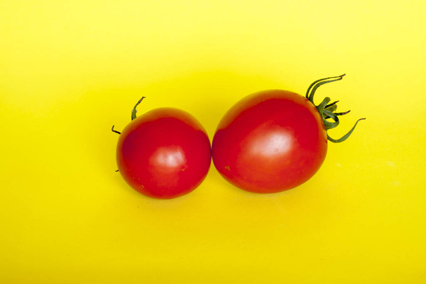 Tomates rojos frescos sobre fondo amarillo
 - Foto, Imagen