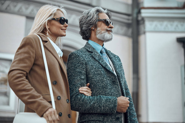 Mature couple in coats and sunglasses stock photo - Φωτογραφία, εικόνα