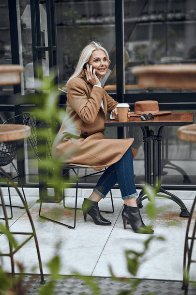 Smiling woman talking on the phone in cafe stock photo - Fotoğraf, Görsel