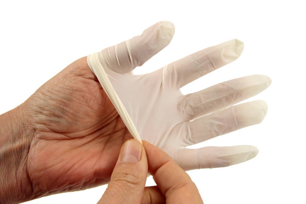 Put on a latex surgical glove in close-up on a white background - Photo, Image