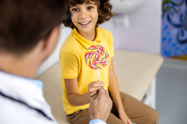 Happy boy with candy near doctor stock photo - Фото, изображение