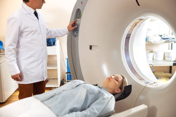Lady lying on CT scanner bed during tomography test in hospital - Photo, Image