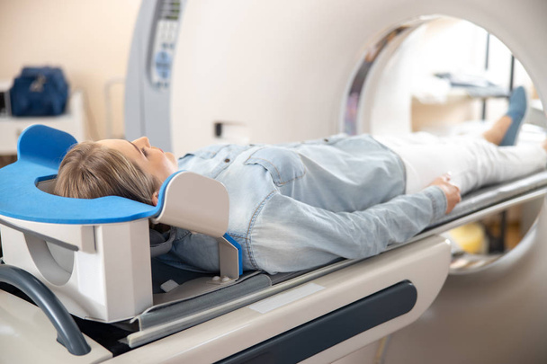 Young woman having computed tomography procedure at hospital - Photo, image