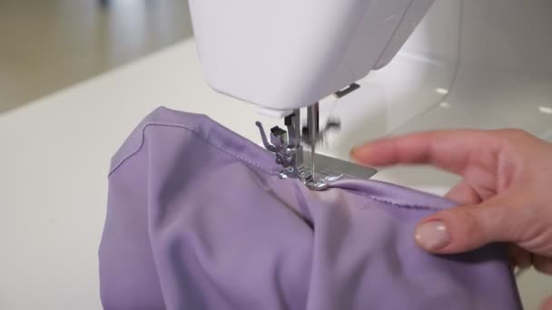 Travaux de couture à la machine à coudre fait des coutures droites sur le tissu, les mains gros plan
. - Séquence, vidéo