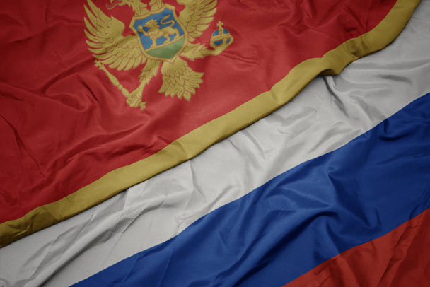 махаючи барвистим прапором Росії і національним прапором чорногорії
. - Фото, зображення
