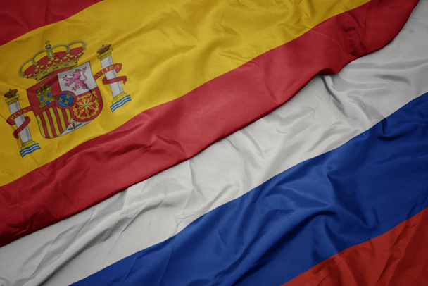 ondeando colorida bandera de Rusia y bandera nacional de España
. - Foto, imagen