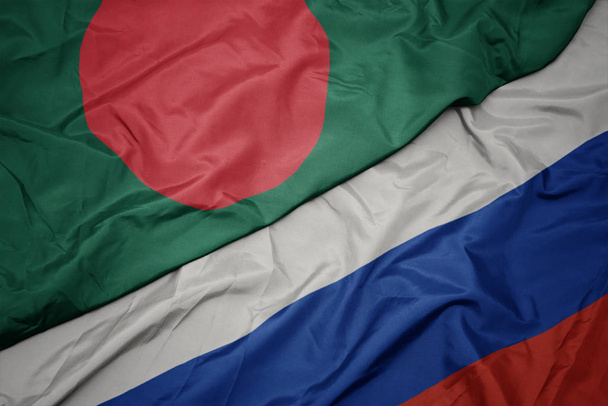 schwenken bunte Flagge von Russland und Nationalflagge von Bangladesh. - Foto, Bild