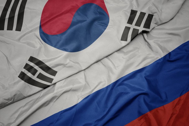 ondeando colorida bandera de Rusia y bandera nacional de Corea del Sur
. - Foto, Imagen