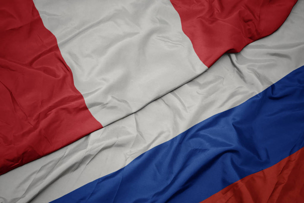 schwenken bunte Flagge von Russland und Nationalflagge von Peru. - Foto, Bild