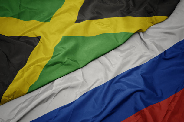 falujące kolorowe flagi Rosji i flagi narodowej Jamajki. - Zdjęcie, obraz