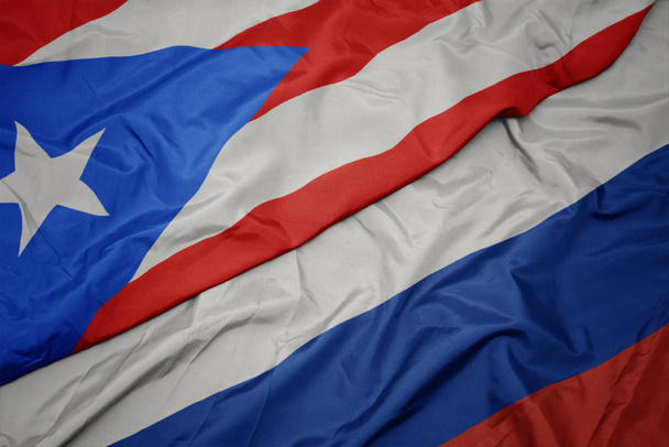 размахивая красочным флагом России и национальным флагом Пуэрто-Рико
. - Фото, изображение