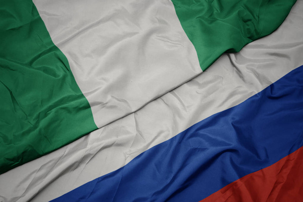 az orosz zászló színpompás zászlója és Nigéria nemzeti zászlaja. - Fotó, kép