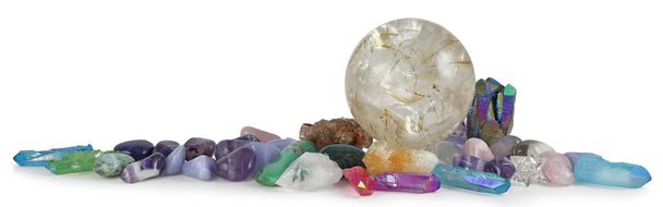 Fila de cristais de cura multicoloridos Bandeira de fundo - Enorme bola de cristal rutilada cercada por várias pedras curativas caídas e quartzo terminado com espaço para cópia
 - Foto, Imagem