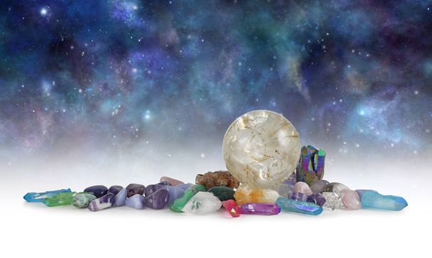 Cosmic Space Crystals Background Banner - Enorme bola de cristal rutilada cercada por pedras curativas caídas e quartzo terminado com espaço para cópia acima no céu escuro celestial
 - Foto, Imagem