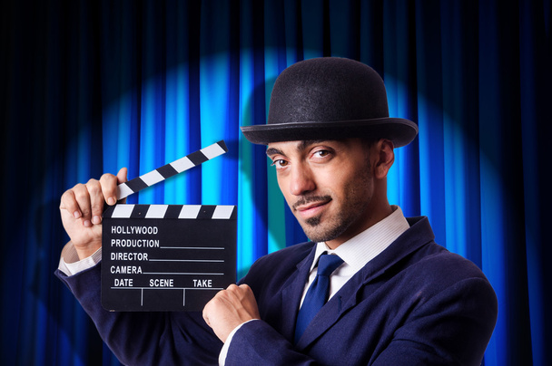 Man with movie clapper on curtain background - Photo, Image