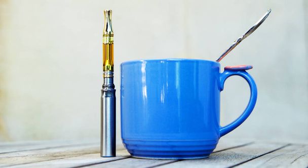 cup of coffee with bottle of CBD oil - Photo, Image