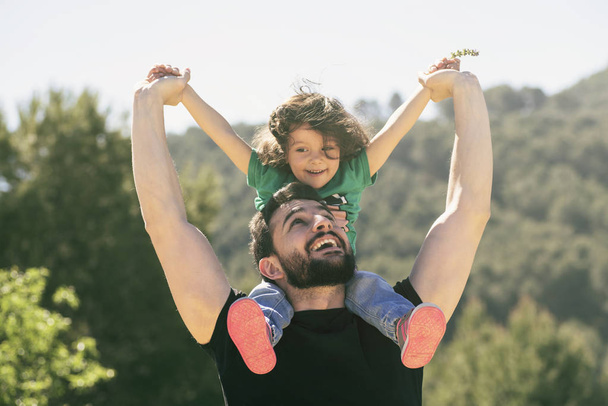 father and daughter playing outdoors in day light - Photo, image