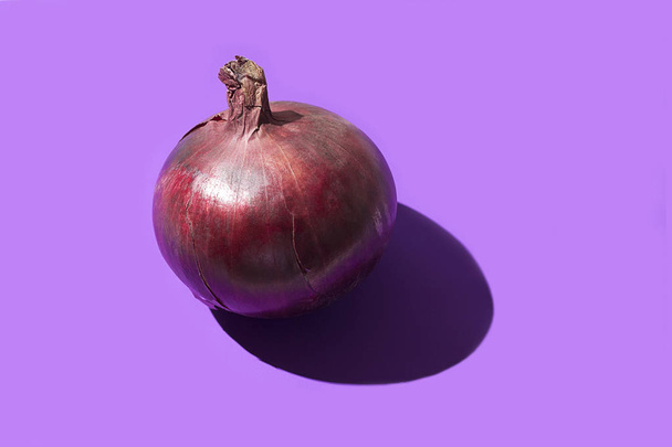 Czerwona cebula na fioletowym tle, Słodka cebula do sałatek i potraw - Zdjęcie, obraz