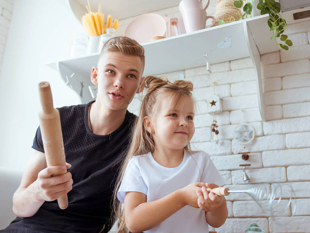 caucasian funny cute siblings in kitchen -  little girl with older brother baking in kitchen. Bake and culinary concept - Photo, Image