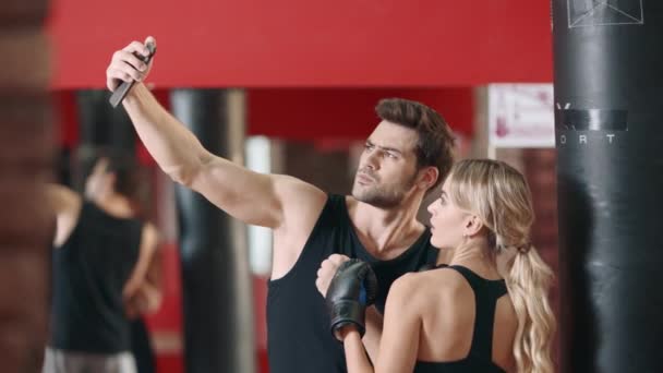 Fitness eğitmeni eğitimden sonra kadın boksör ile mobil selfie yapıyor. - Video, Çekim