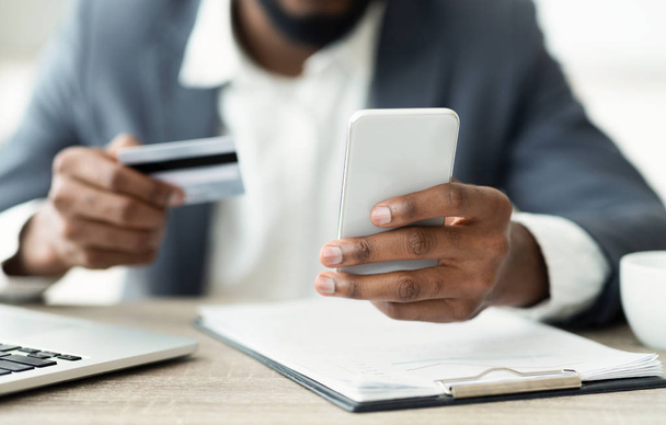 Hombre usando tarjeta de crédito y teléfono inteligente para ir de compras en Internet
 - Foto, imagen