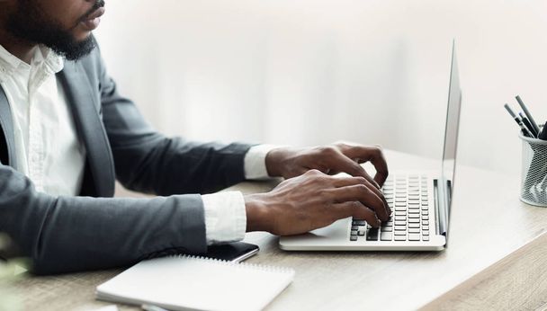 Onherkenbaar zakenman werkt op laptop in modern kantoor - Foto, afbeelding