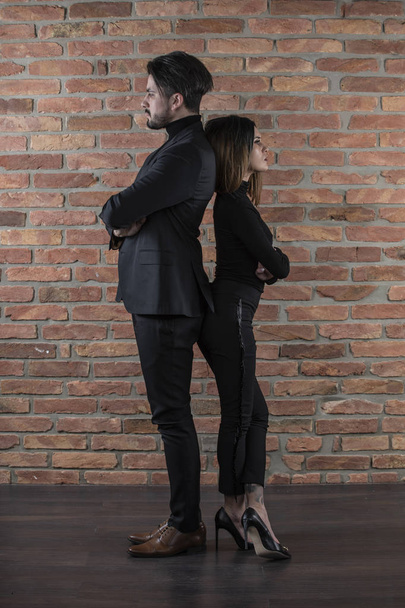 Hermosa joven pareja de negocios de pie espalda con espalda delante de
 - Foto, Imagen