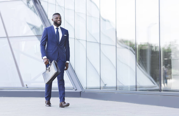 Empresário negro bem sucedido com pasta andando na área urbana
 - Foto, Imagem