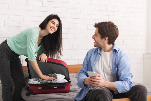 Paar bereitet sich auf Reise vor, Frau packt Koffer - Foto, Bild