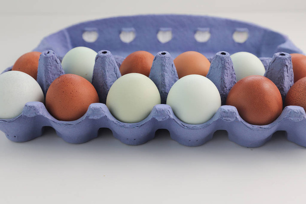 Hnědá Kuřecí vejce v modrém krabici izolovaná na bílém pozadí. - Fotografie, Obrázek