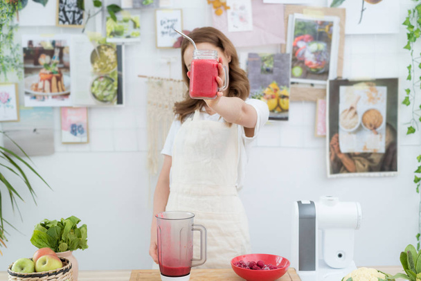 Beautiful girl holding a freshly made smoothie from berries. The concept of a healthy diet, healthy lifestyle. - 写真・画像