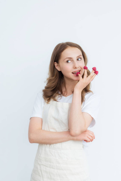Beautiful girl holding raspberries on her fingers. Healthy eating, fruit diet, healthy lifestyle concept. - Foto, imagen