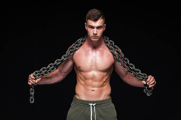 The Perfect male body - Awesome bodybuilder posing. Hold a chain. Isolated on white background. Copy Space. - Foto, Imagen