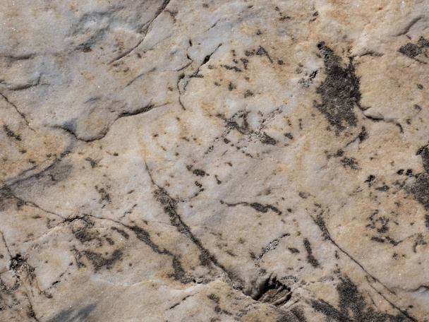   テクスチャディテール、クローズアップ、抽象的な自然グランジ背景を持つ古い光花崗岩の素朴で粗い石の中心に選択的な焦点. - 写真・画像