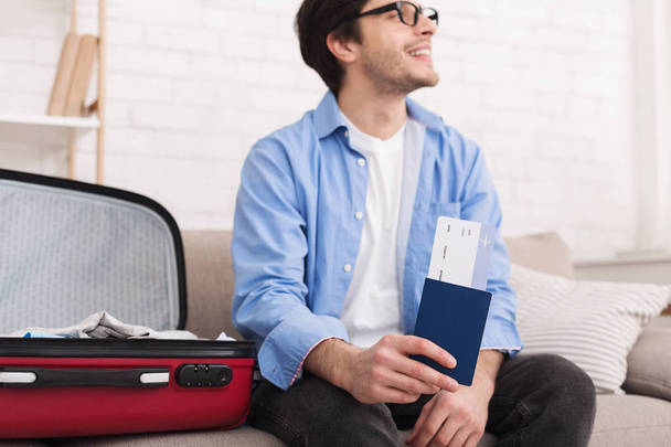Hombre feliz con pasaporte y billete en casa
 - Foto, imagen
