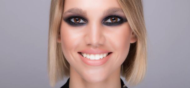 Wide and bright smile. Sexy model with strong make up. - 写真・画像