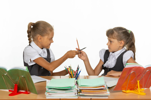 Две девушки дерутся карандашами за школьным столом
 - Фото, изображение
