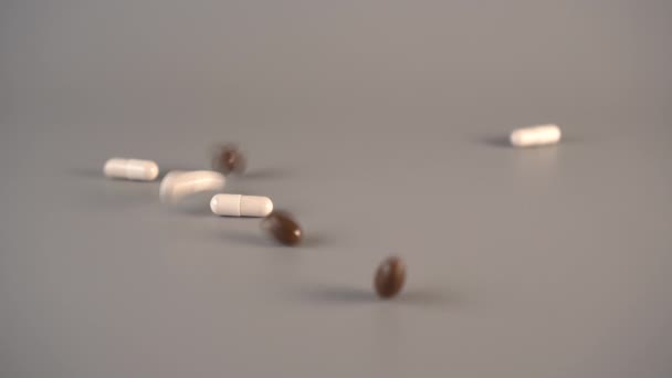 Brown and white medical capsules fall on a wooden table, bouncing in different directions. The concept of innovative drugs - Imágenes, Vídeo