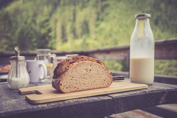 Rustic breakfast on an alpine hut: fresh crisp bread and milk in - Fotografie, Obrázek