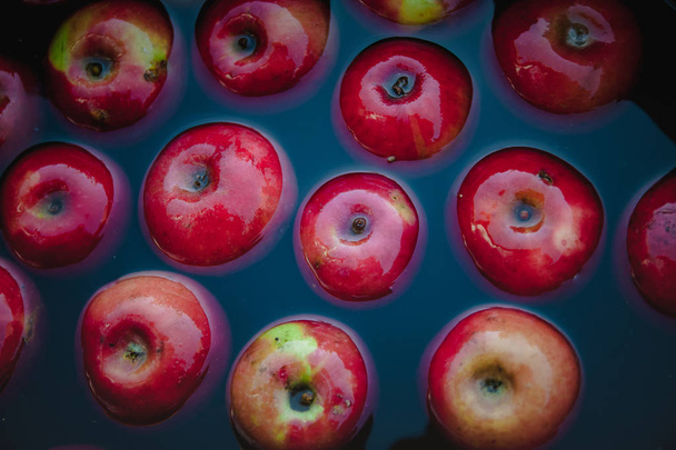 Manzanas rojas jugosas en el agua en un cubo. Tendencia fondo retro oscuro. Concepto, cosecha rica. Vista superior
. - Foto, imagen