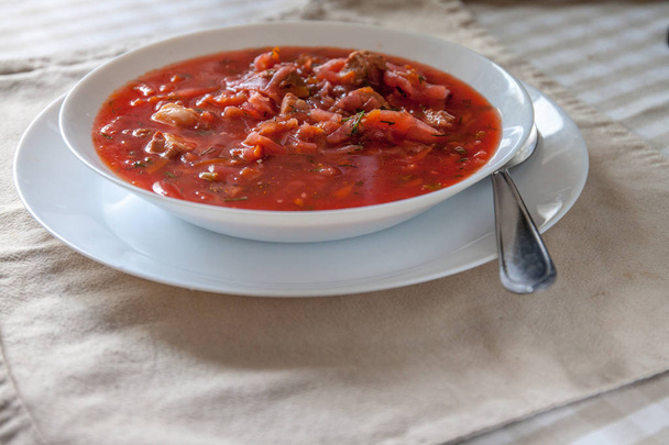 tradiční ukrajinština-Ruská rajčatová polévka s kyselou smetanou v bílé desce na stole. Pohled shora. - Fotografie, Obrázek