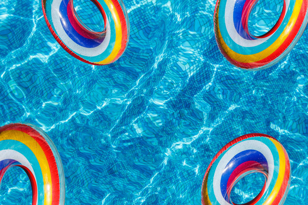 Actividades acuáticas inflables cuatro círculos tuba flotan en el agua en la piscina. pancarta, espacio de copia.Concepto, diversión, alegre verano y relajación
. - Foto, Imagen