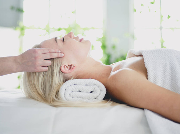 Young woman enjoying massage in spa salon - Фото, зображення