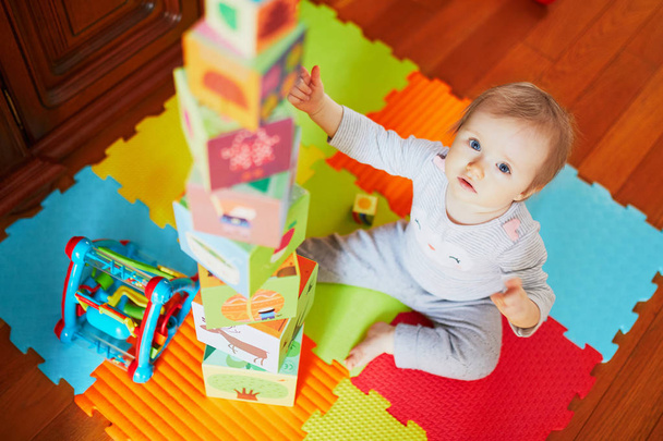Чарівна маленька дівчинка будує вежу вдома
 - Фото, зображення