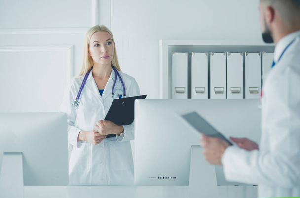 Woman doctor standing with folder at hospital - 写真・画像