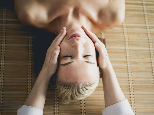 Beautiful woman doing facial massage in a spa salon - Фото, изображение
