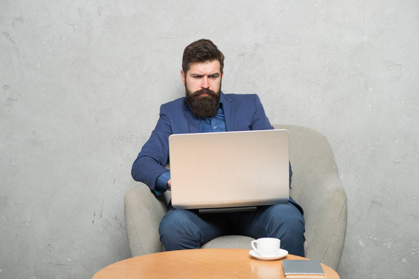 Getting business information surfing the Internet. Businessman making Internet project at laptop. Bearded man using mobile Internet connection. The Internet is the great equalizer in business - Photo, Image