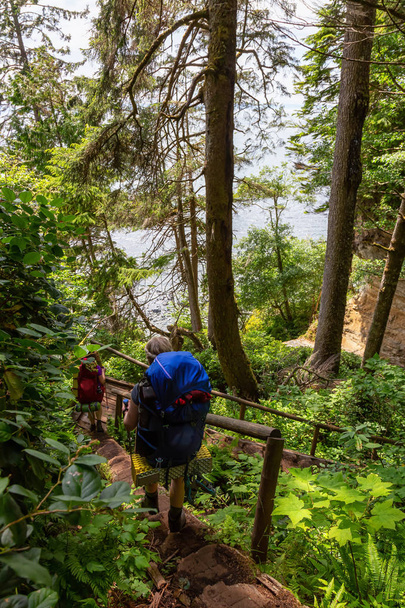 Adventurous female is hiking Juan de Fuca Trail near Mystic Beach on the Pacific Ocean Coast during a sunny summer day. Taken near Port Renfrew, Vancouver Island, BC, Canada. - 写真・画像