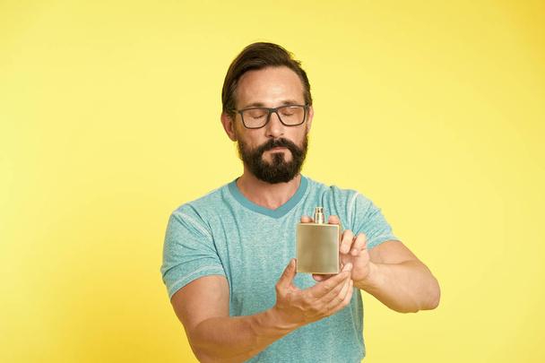 How choose perfume for men according to occasion. Make sure smell fresh throughout day. Amazing benefits of using perfumes. Man bearded handsome hold bottle perfume. Wearing perfume is enhancing mood - 写真・画像